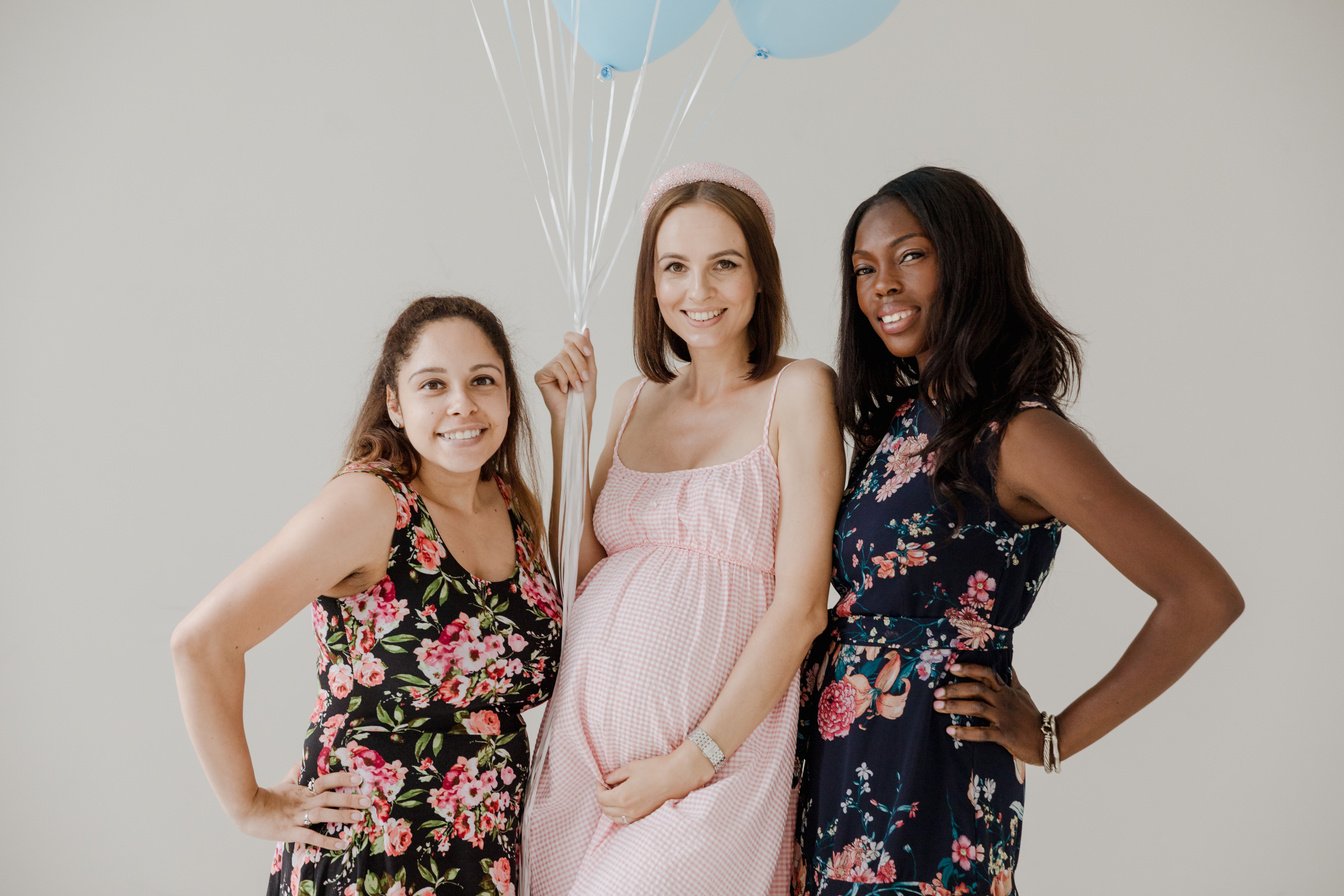 Pregnant Woman Posing with Friends Holding Balloons